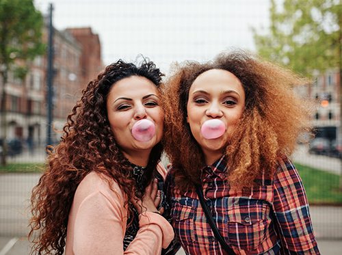 Two girls with chewing gum