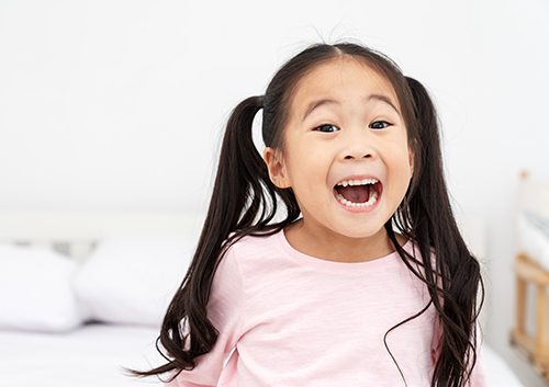 A kid showing her wide open mouth