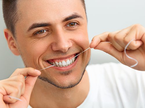 A man flossing his teeth