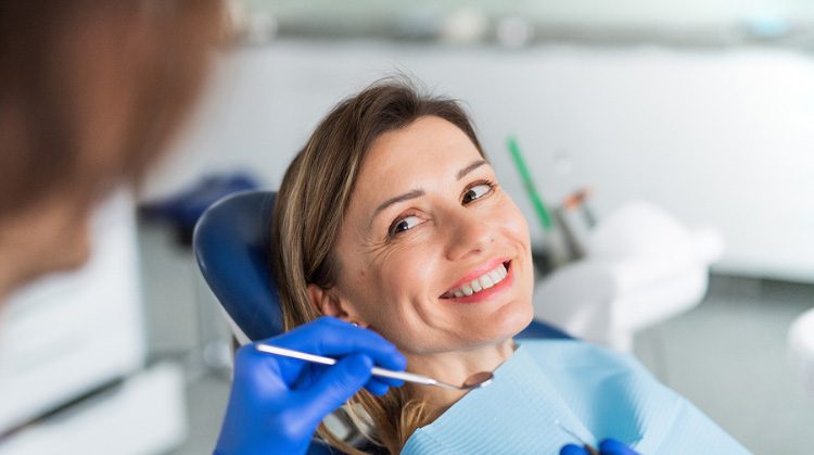 Smiling woman receiving a dental checkup.